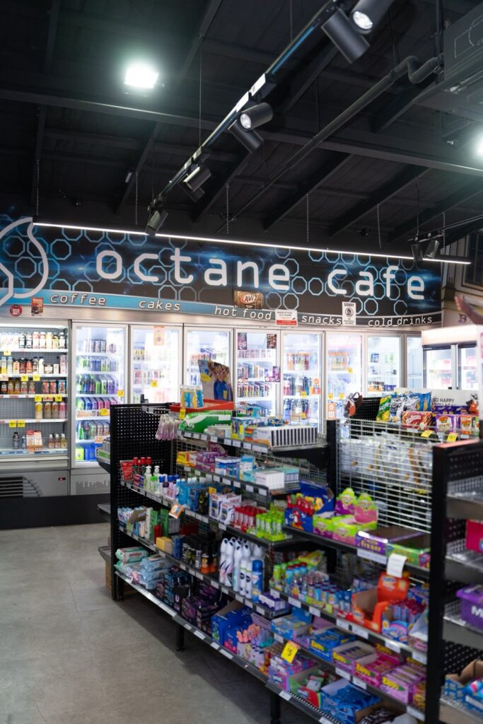 Inside an Octane Café store with drinks fridges and snack shelves under the Octane Café sign